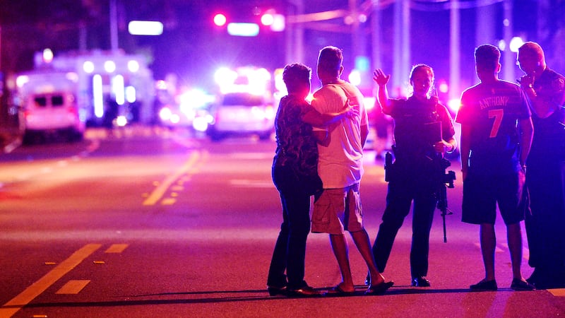FILE - In this June 12, 2016, file photo an Orlando Police officers direct family members away...