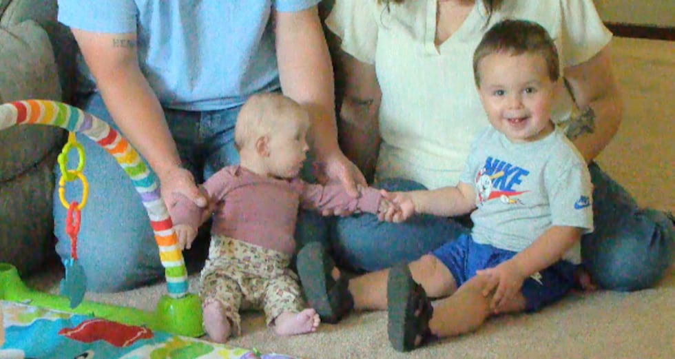 Millie Dwyer, 5 months, is pictured holding hands with her older brother, Henry Dwyer.