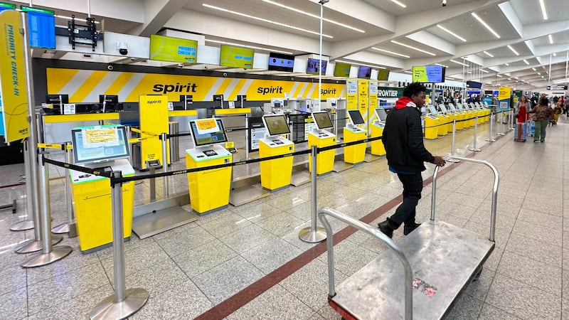 Spirit Airlines’ counter is passed by an airport employee after the airline’s shutdown on...