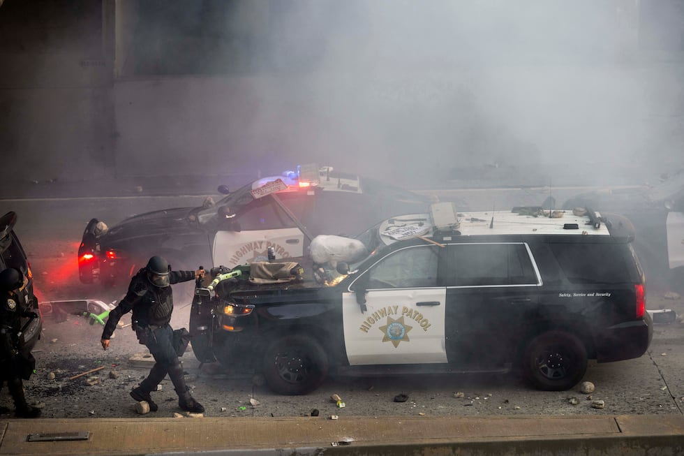 A California Highway Patrol officer pulls an electric scooter off a vehicle on a highway as...