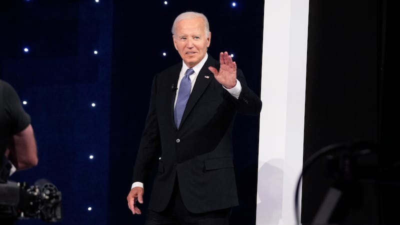 President Joe Biden gestures as he takes the stage at the start of a presidential debate...