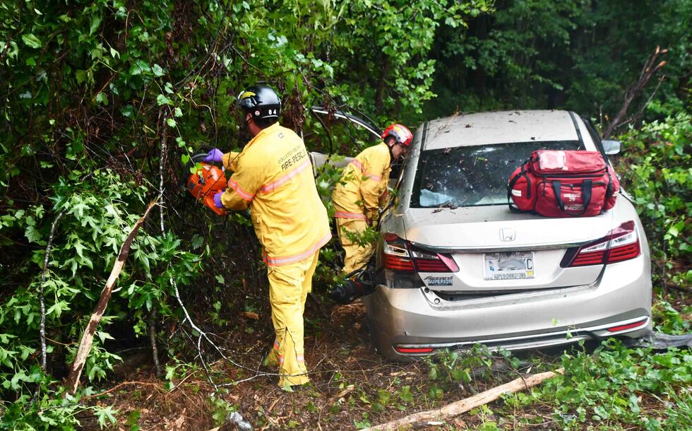 A woman has been hospitalized after a crash left her trapped in her vehicle.